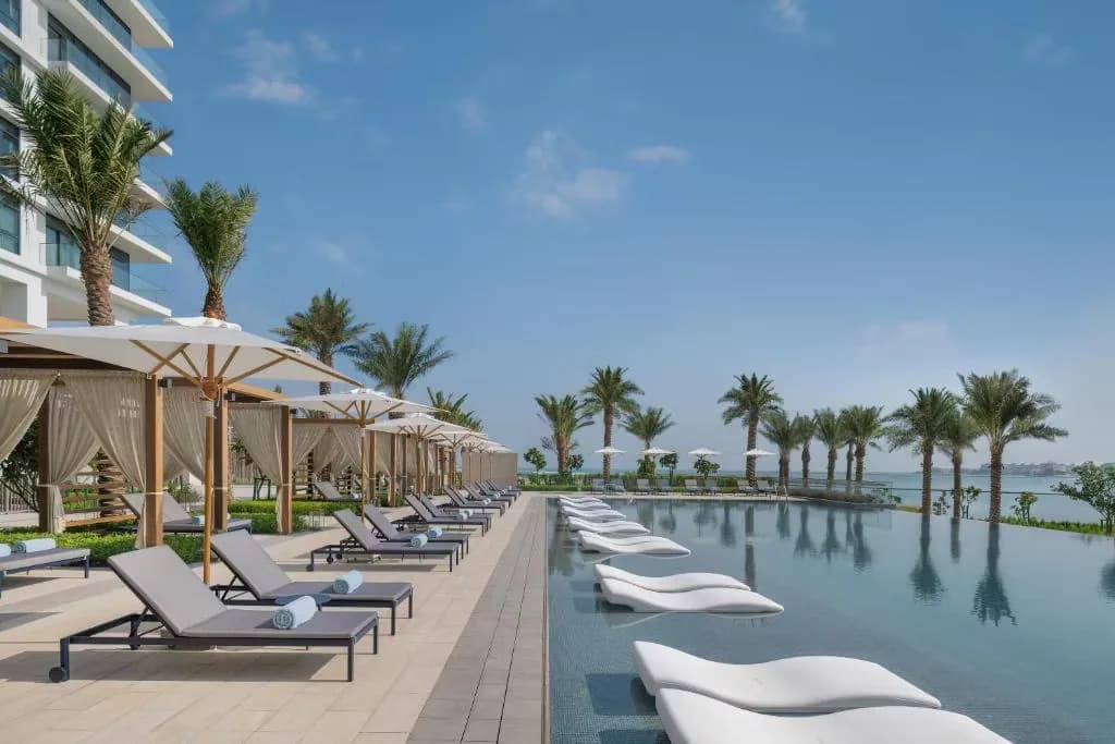 Beachfront loungers and pool at Address Beach Resort Bahrain