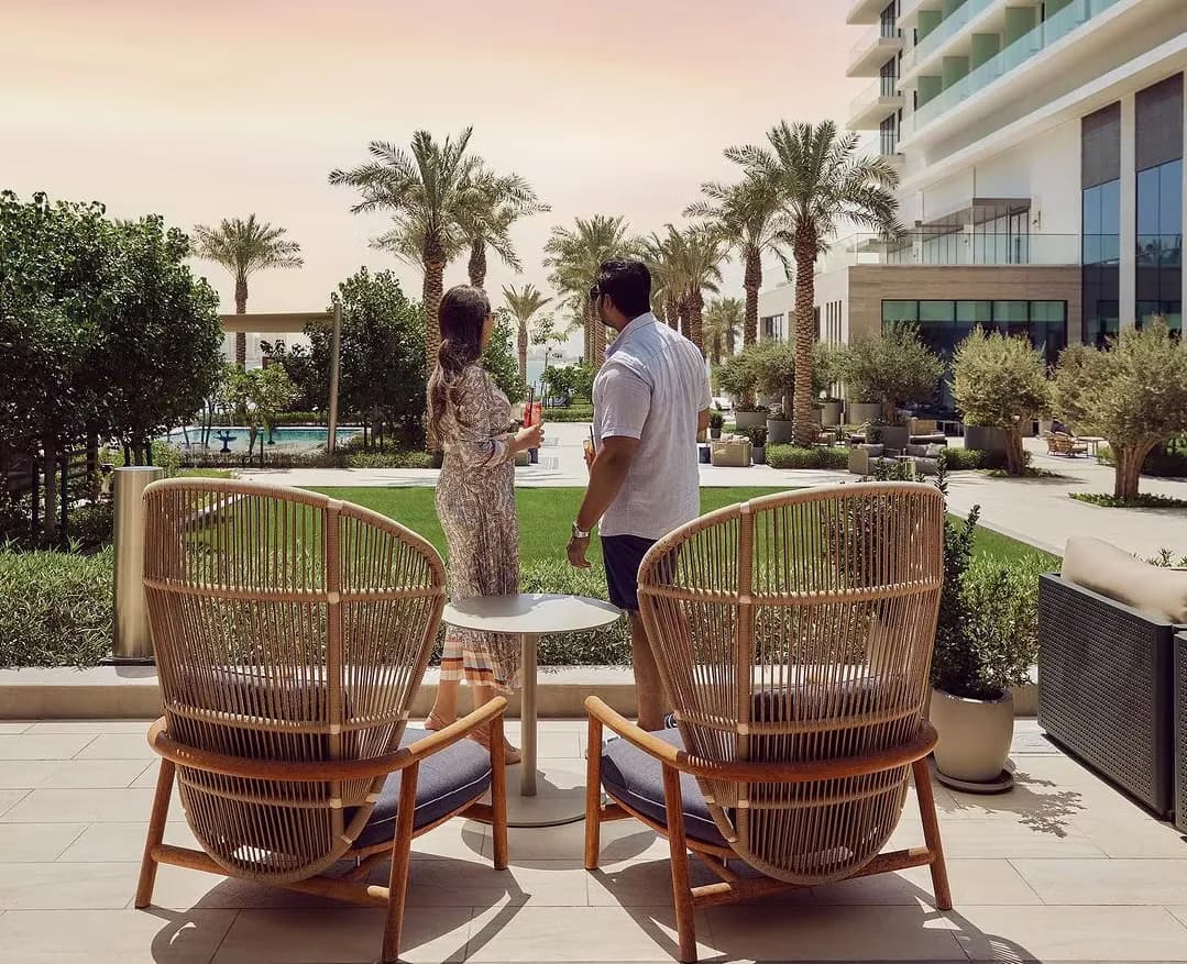 Guests relaxing in woven chairs in the resort garden